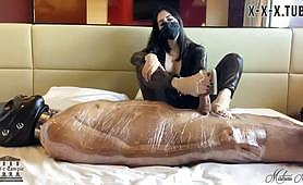 Mistress Nara Abusing mummified slave with foot trampling shoejob